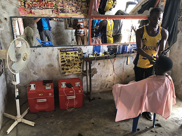 A kid getting a hair in a powered barber shop in Africa